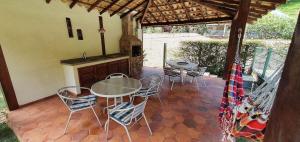 a patio with a table and chairs and a kitchen at Casa Família, piscina, hidro aquecida, cercada in Petrópolis