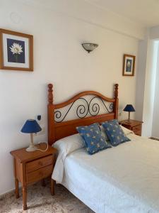 um quarto com uma cama com duas almofadas azuis em Apartamento vacacional Jávea em Xàbia
