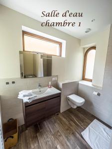 a bathroom with a sink and a toilet and a mirror at Gîte le coeur d'Alsace in Boofzheim