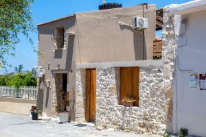 una piccola casa con porte in legno su una strada di Ariadni's House a Knossós