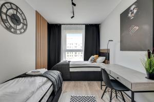 Schlafzimmer mit einem Bett, einem Schreibtisch und einem Fenster in der Unterkunft Dom & House - Apartments Angielska Grobla in Danzig