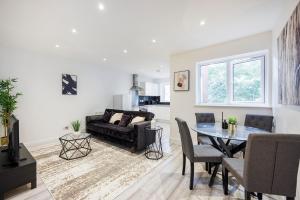 ein Wohnzimmer mit einem Tisch und einem Sofa in der Unterkunft Modern apartment -Perfect for Contractors & Families By Luxiety Stays Serviced Accommodation Southend on Sea in Southend-on-Sea