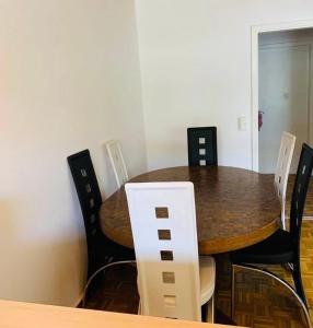 mesa de comedor con sillas blancas y negras en MYM NOW Apartment in Bern, en Berna