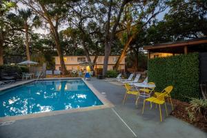 a pool with chairs and a table and a table and chairs at Queen's Court Inn in Saint Simons Island
