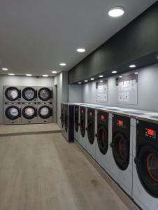a laundry room with a row of washers and dryers at Cosy apt à 200m de la Cathédrale in Liège