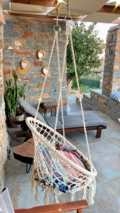 einen hängenden Hängesessel auf einer Terrasse mit einem Tisch in der Unterkunft Gaia Vacation Home in Agia Mavra