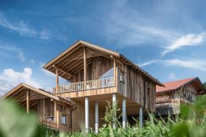 uma grande casa de madeira com uma varanda no topo em DILIA Chalets & Apartments em Mühlbach