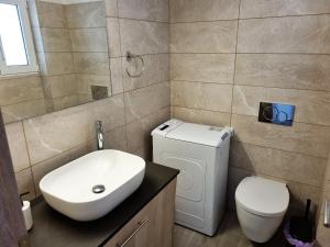 a bathroom with a white sink and a toilet at WOW Penthouse Boutique in the heart of Historical Center in Athens