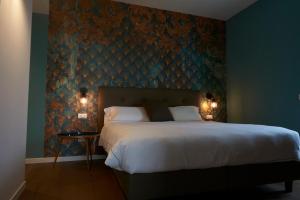 a bedroom with a large bed and a blue wall at Hotel B&B il Mosaico in Sirmione +37 photos