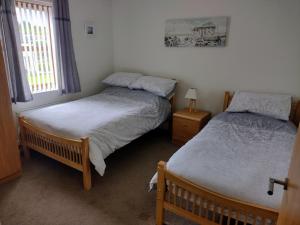 a bedroom with two twin beds and a window at Mournes Snug in Newcastle