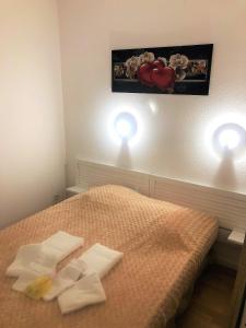 1 dormitorio con 2 toallas en una cama con 2 luces en Appartement 6 personnes totalement rénové avec piscine, en Le Verdon-sur-Mer