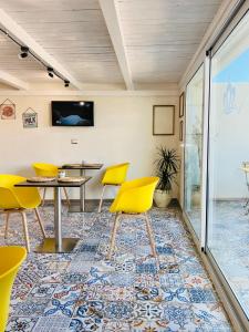 a room with yellow chairs and a table at Regina Elena Rooms in Avola