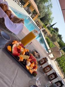 un piatto di frutta su un tavolo accanto a una piscina di Côté vignes cassis a Cassis