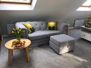 a living room with a couch and a table at Round-y-Corner in Macclesfield