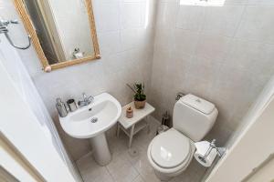 La salle de bains blanche est pourvue de toilettes et d'un lavabo. dans l'établissement Casa Francesca, à Vrahati