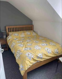 un letto con una coperta gialla e fiori sopra di Self contain apartment on the Barbican 3 bed a Plymouth