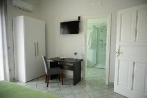 a bedroom with a desk and a shower at Flowers' House in Castellammare di Stabia