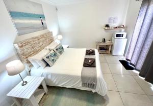 Dormitorio pequeño con cama y mesa en Always Summer Guesthouse, en Langebaan