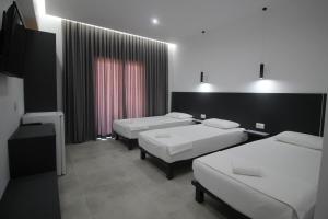 Pokój z 3 łóżkami i telewizorem w obiekcie Art De Jon Rooms w Sarandzie