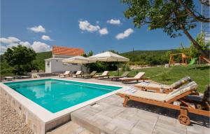 una piscina con sedie a sdraio e una casa di Lovely Home In Lokvicici With Wifi a Lokvičič