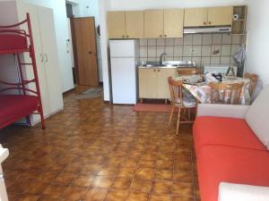 een keuken met een rode bank en een keuken met een koelkast bij Casa Lu’ in Mongiove
