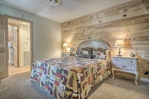 a bedroom with a bed and a wooden wall at Furnished Deck and Grill Rustic Pigeon Forge Cabin in Pigeon Forge +24 photos