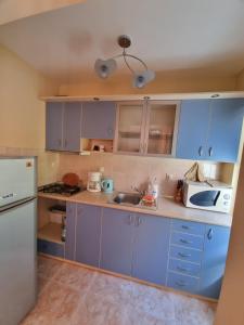 a kitchen with blue cabinets and a sink at Нашето място in Pomorie
