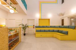a room with a yellow couch in a store at Locul Midtown-Indiranagar in Bangalore