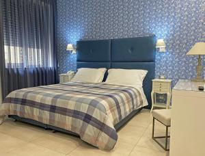a blue bedroom with a bed and a blue wall at Viva Hotel Avellino in Avellino +96 photos