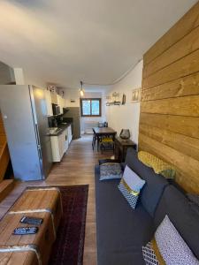 a living room with a couch and a kitchen at Maison village proche Andorre et stations de ski in Porté-Puymorens