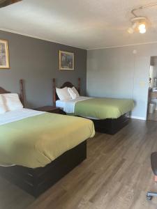 een hotelkamer met 2 bedden en een stoel bij Travel Inn in Broadview