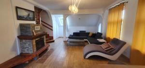 uma sala de estar com um sofá e uma lareira em Mazurska przystań em Dabrówno