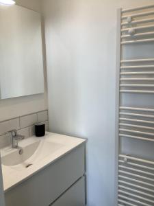 Un baño blanco con lavabo y espejo. en Trinquet Bordatxo, en San Juan de Luz 14 fotos más