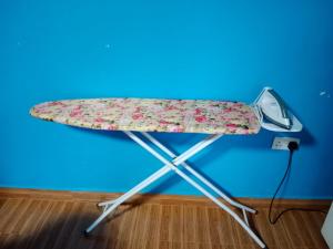 a ironing board on a table against a blue wall at The kioka gardens with Wifi and parking in Nanyuki