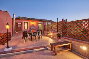 a patio with a table and chairs and a fence at al VICOLO VI in Sardara
