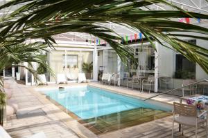 a pool with a palm tree in a building at Hotel Ciudad del Sol in Termas de Río Hondo