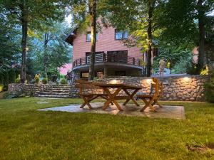 a picnic table and bench in front of a house at Sky Villa Brezovice in Brezovica