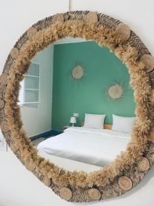 Un dormitorio con un gran espejo circular sobre una cama en WELKAM Home & Coworking, en Essaouira