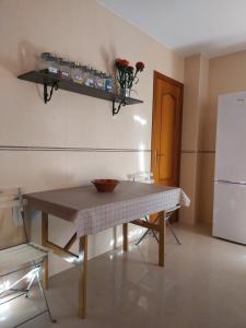 a small kitchen with a table and a refrigerator at Alojamiento en Bujalance in Bujalance