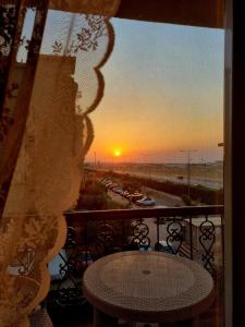 a view of a sunset from a balcony with a table at Hayat Al-Rehab Apartment in Cairo