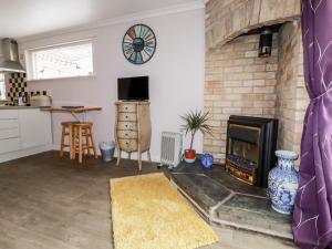 a kitchen and living room with a brick fireplace at The Studio in Bodmin