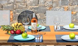a table with a bottle of wine and fruit on it at Sissi Lux Villas in Sisi
