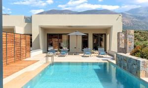 a villa with a swimming pool with mountains in the background at Sissi Lux Villas in Sisi