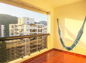 a balcony with hammocks and a view of a city at Apto a 200 m da Praia das Pitangueiras-Guaruja SP in Guarujá