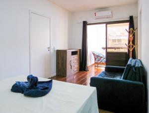 a living room with a table and a couch and a window at Apto a 200 m da Praia das Pitangueiras-Guaruja SP in Guarujá +33 photos