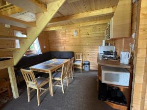 a kitchen with a table and chairs in a cabin at Forest Guest House 2 in Sîntimbru-Băi