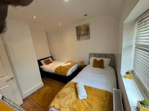 een slaapkamer met 2 bedden en een raam bij Fabulous 3 bedroom house , sleeps up to 5-7 guest. in South Ockendon