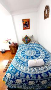 1 dormitorio con 1 cama con alfombra azul y blanca en Hostel mágico San Blas, en Cusco