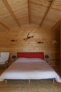 a bedroom with a bed in a wooden ceiling at CABANE BAMBOU in Fronsac