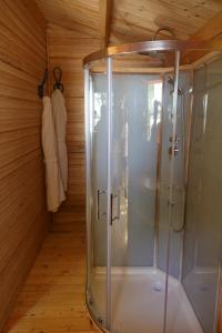 Una ducha a ras de suelo en una habitación con paredes de madera. en CABANE BAMBOU en Fronsac